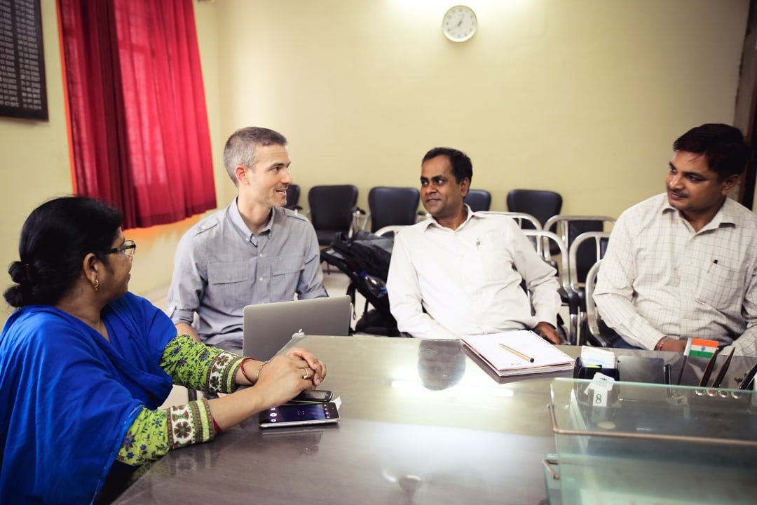 Mighty Ally Co-founder and CEO sitting at a table with leaders from Indian charity, STiR Education