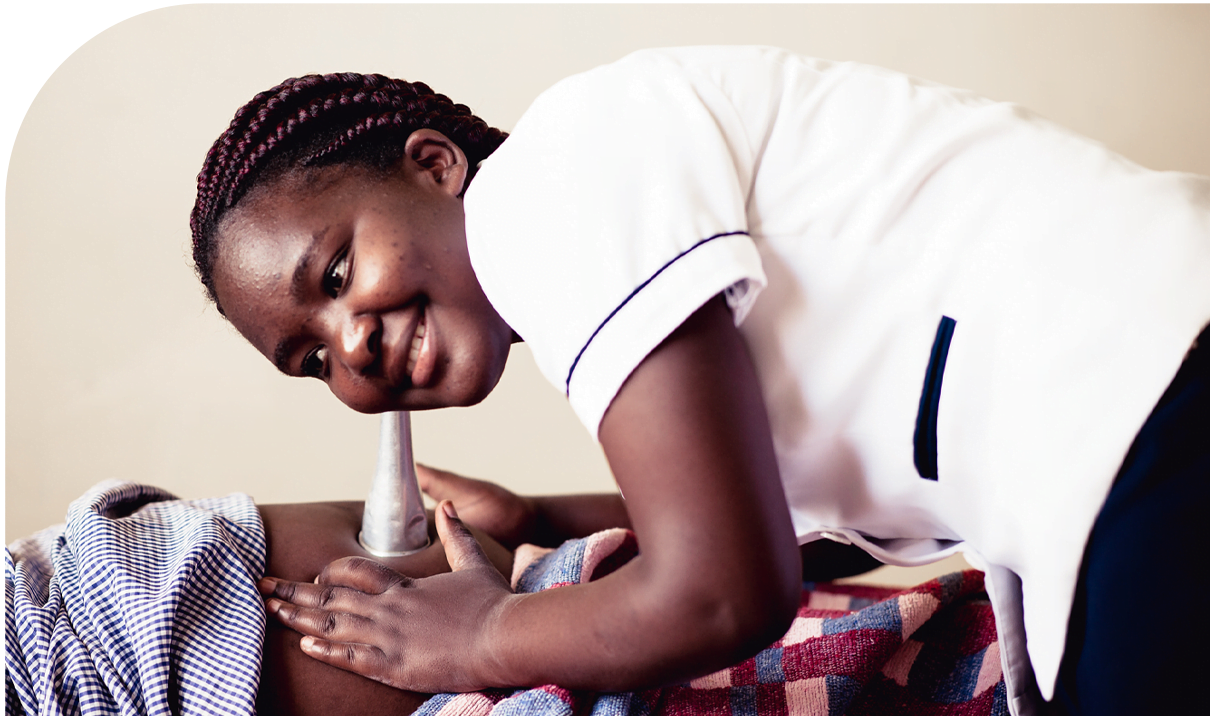 Female Kenyan birth attendant listening to the heartbeat of an unborn child using a metal fetoscope.